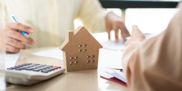 Der Kunde unterzeichnet ein Darlehensdokument, um Häuser mit einem Immobilienmakler oder einem Anwalt zu kaufen. Immobilienmakler und Kunde unterzeichnen Vertrag zum Kauf eines Hauses. Konzept der Versicherungs- oder Darlehensimmobilien